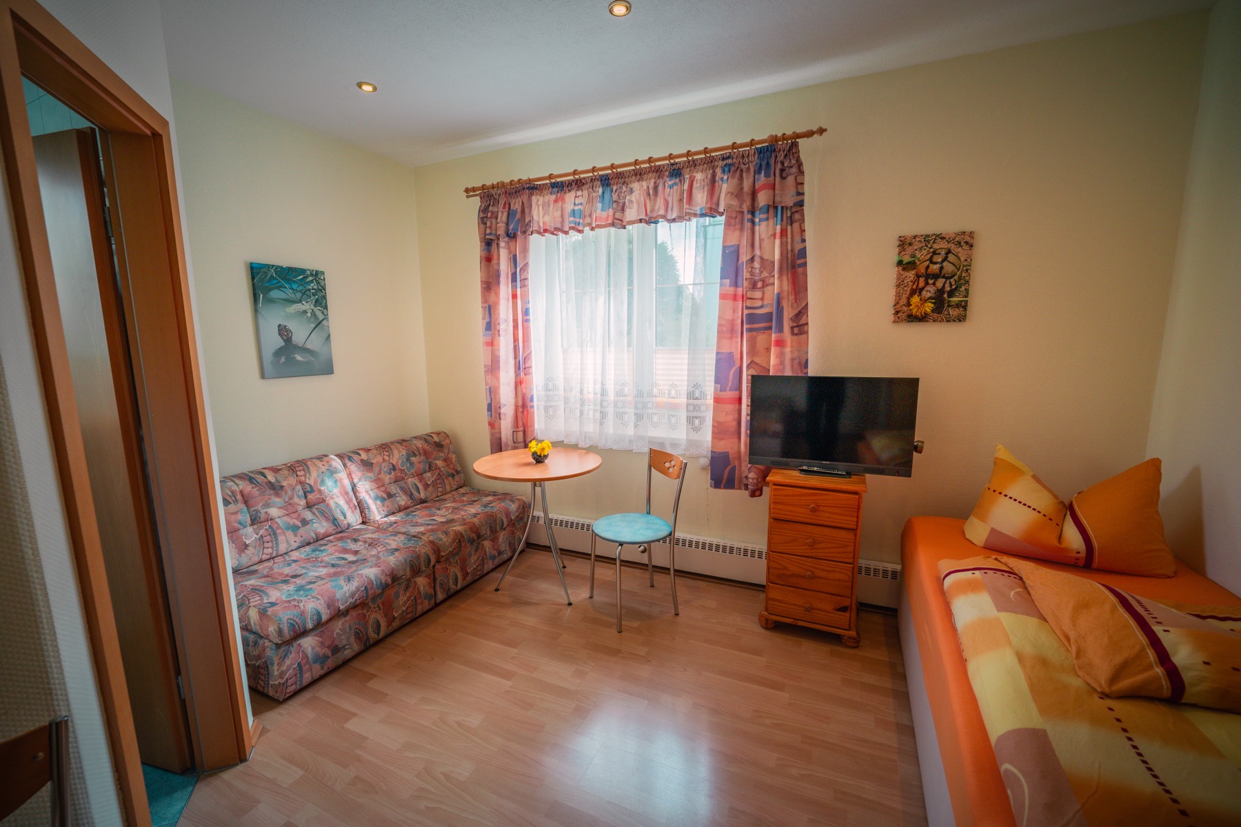 Zweibettzimmer mit Bett, Schlafcouch, TV und Sitzecke